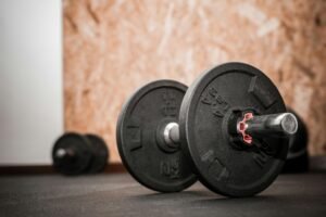 Rustic gym scene showing close-up of dumbbells for weight training.